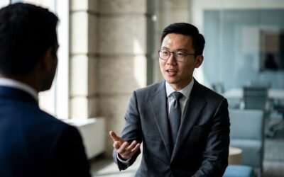 Deux hommes en costume discutent dans un bureau moderne, gestuelle